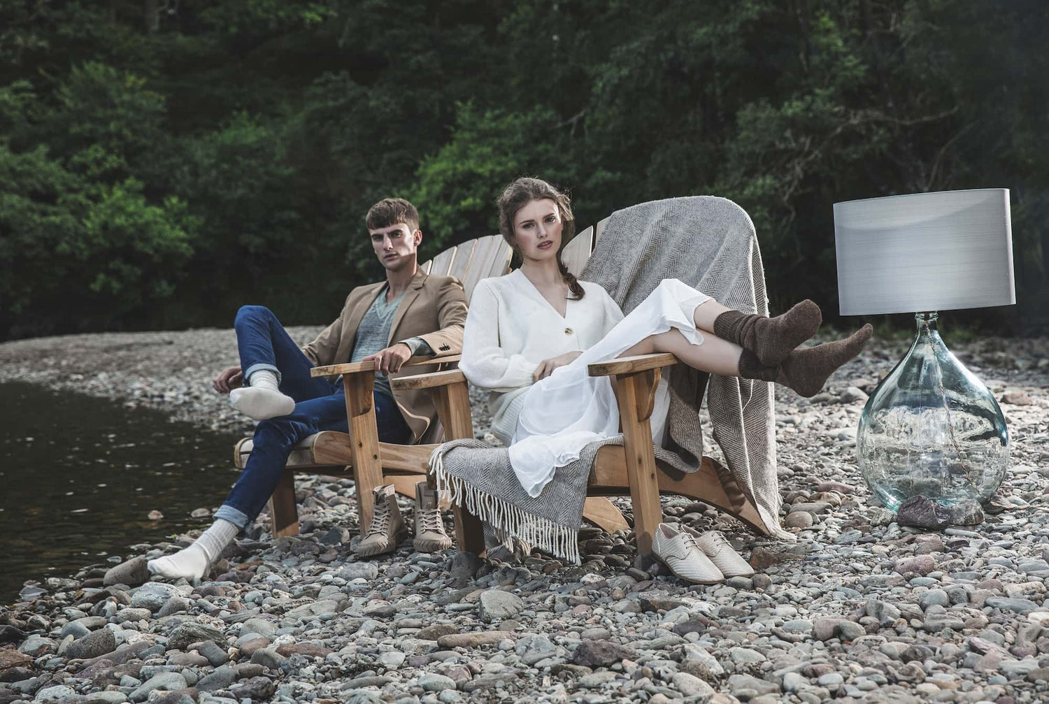 Alpaca bed socks and everyday socks on a man and woman on a pebble beach on a lake in scotland