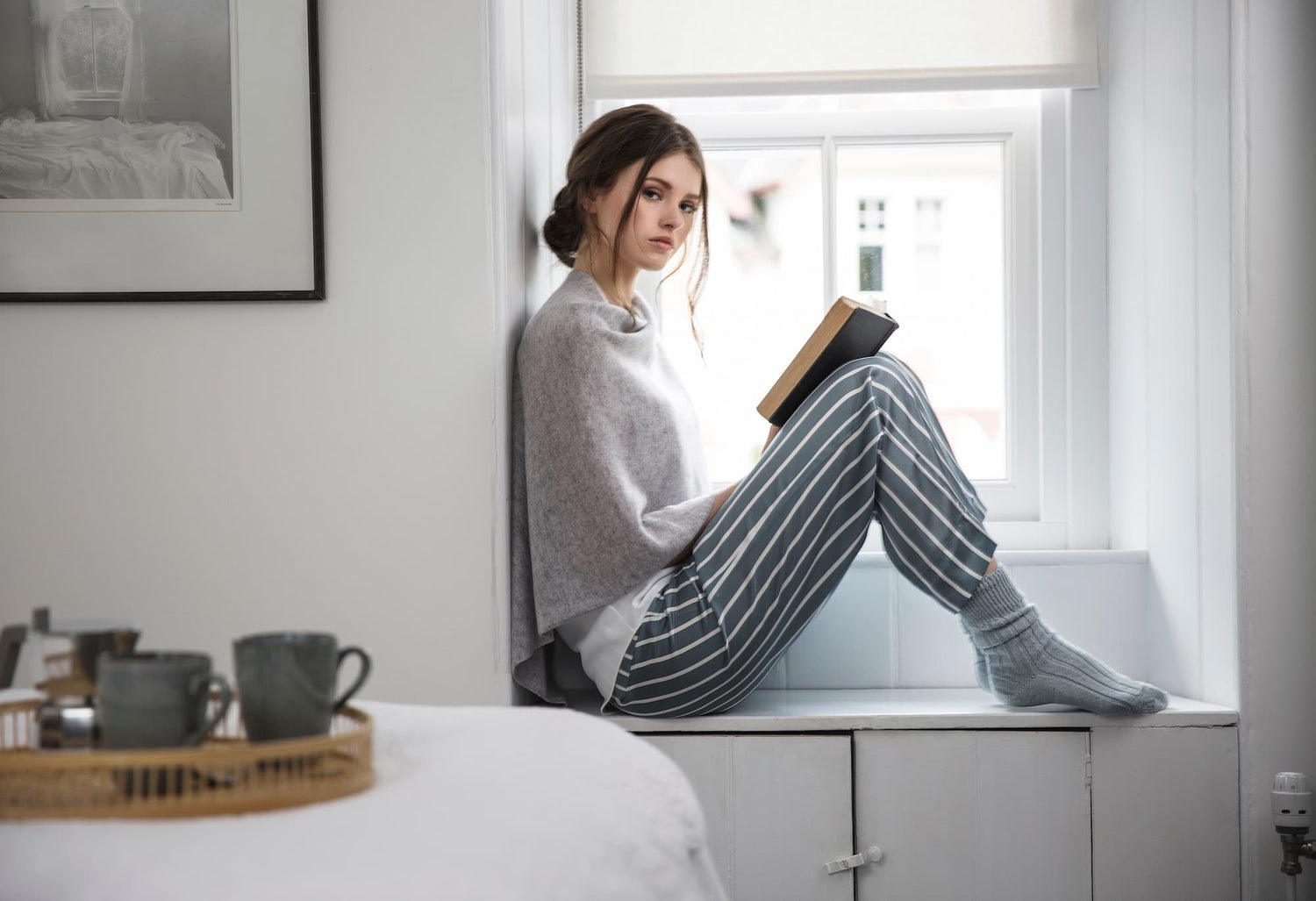 alpaca bed socks on a lady in a bedroom reading a book