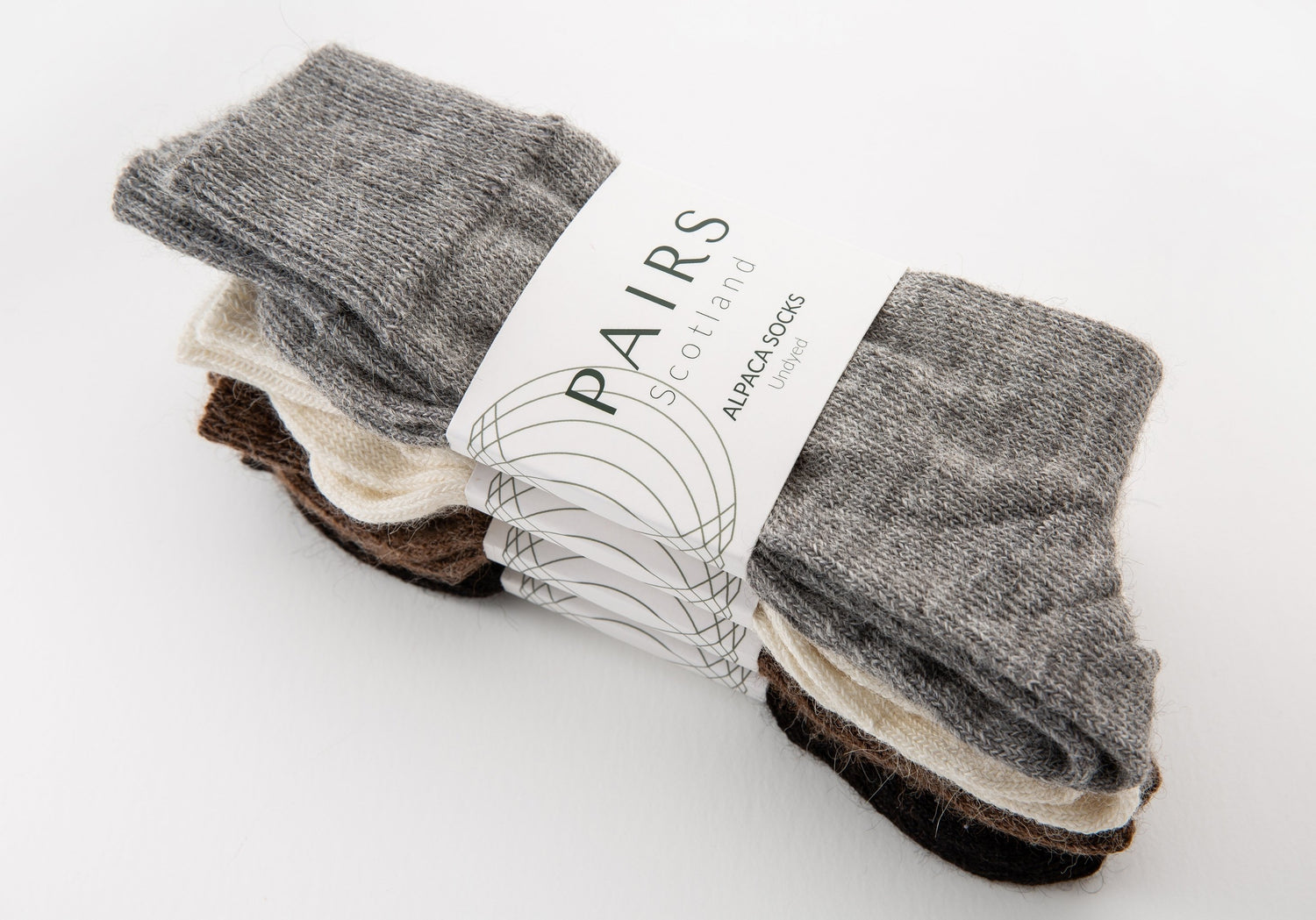 sustainable natural undyed alpaca wool socks product collection, four pairs piled up