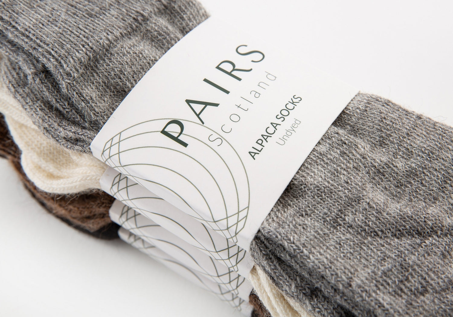 sustainable natural undyed alpaca wool socks product collection, four pairs piled up